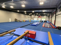 Gymnastics training facility with blue mats and equipment